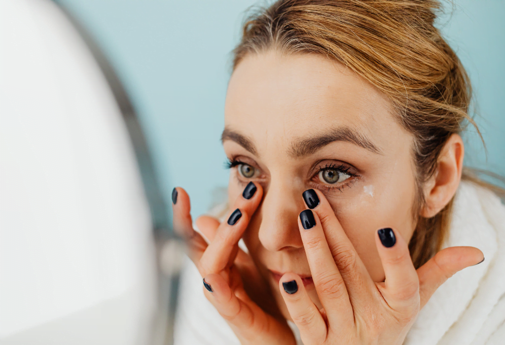 young woman looking at her skin - preventative antiaging with comsetic acupuncture